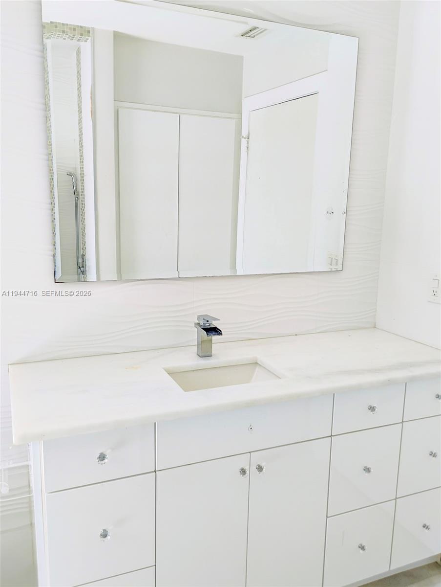 9654 Sun Pointe Drive Boynton Beach, FL 33437 - Photo 38 of 52 a bathroom with a sink and a mirror