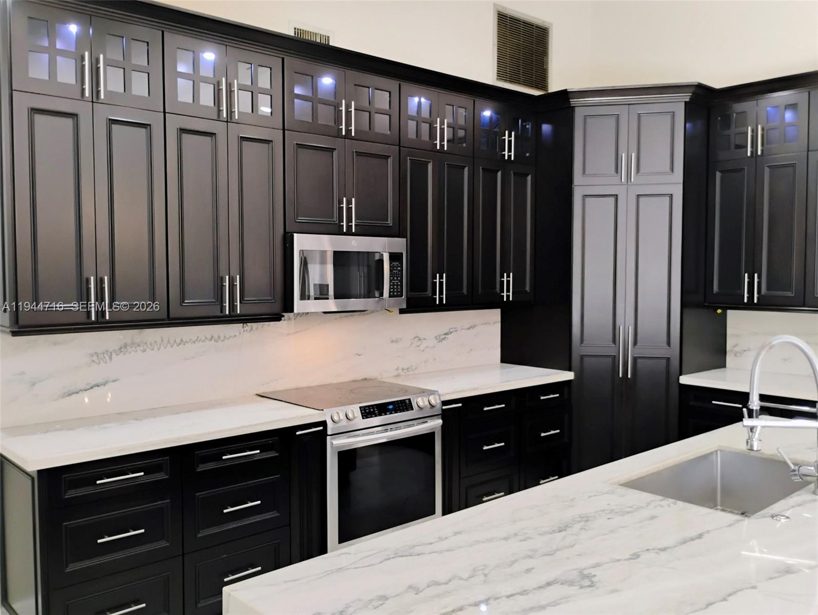 9654 Sun Pointe Drive Boynton Beach, FL 33437 - Photo 8 of 52 a kitchen with a refrigerator and cabinets