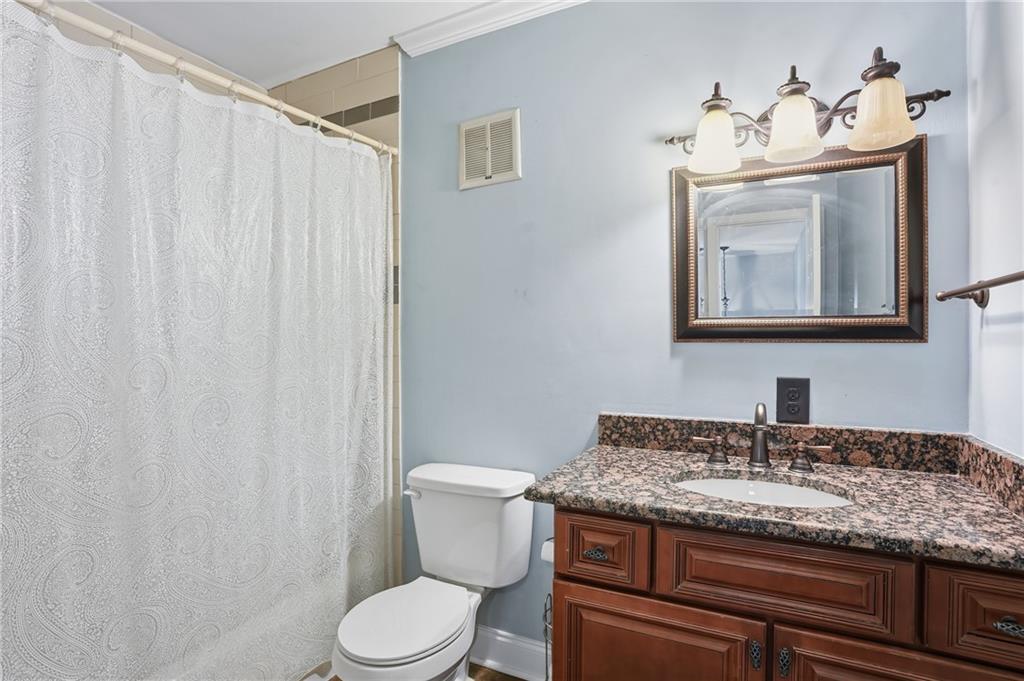 3320 Northcrest Road, Unit C Atlanta, GA 30340 - Photo 15 of 34 a bathroom with a granite countertop sink toilet and mirror