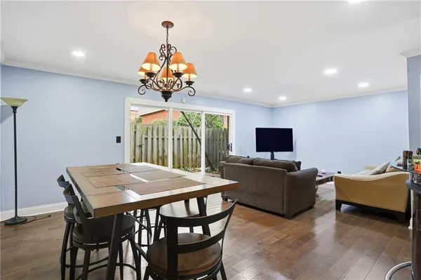 a living room with furniture a flat screen tv and a chandelier