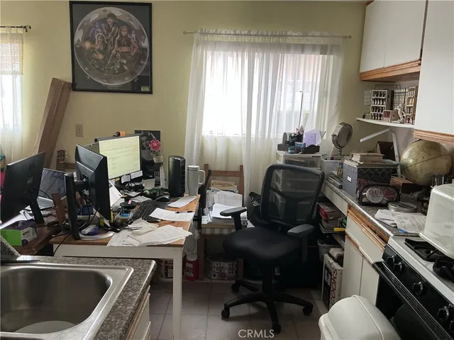 a view of a workspace with furniture and a window