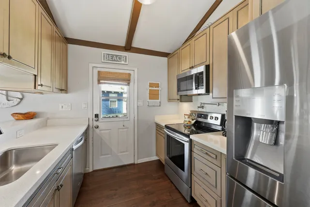 a kitchen with stainless steel appliances a stove a sink and a refrigerator