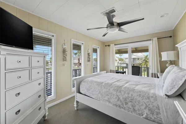 a bedroom with a large bed and a flat tv screen on dresser