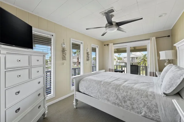 a bedroom with a large bed and a flat tv screen on dresser