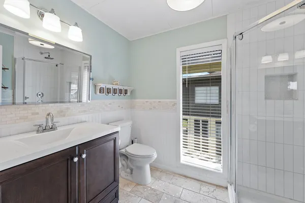 a bathroom with a sink a toilet and shower