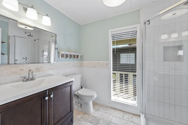 a bathroom with a sink a toilet and shower