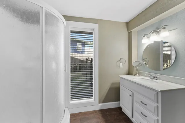 a bathroom with a sink a mirror and a shower