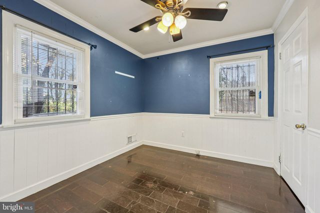 a view of an empty room with a window and a ceiling fan