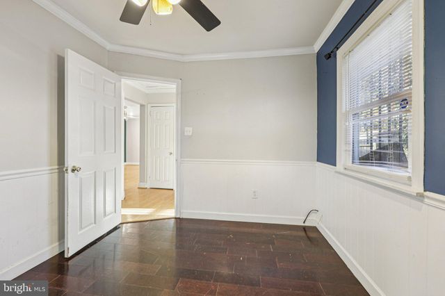 a view of an empty room with chandelier fan and fire place