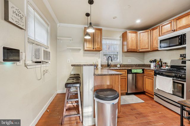 a kitchen with stainless steel appliances a stove a sink and a microwave