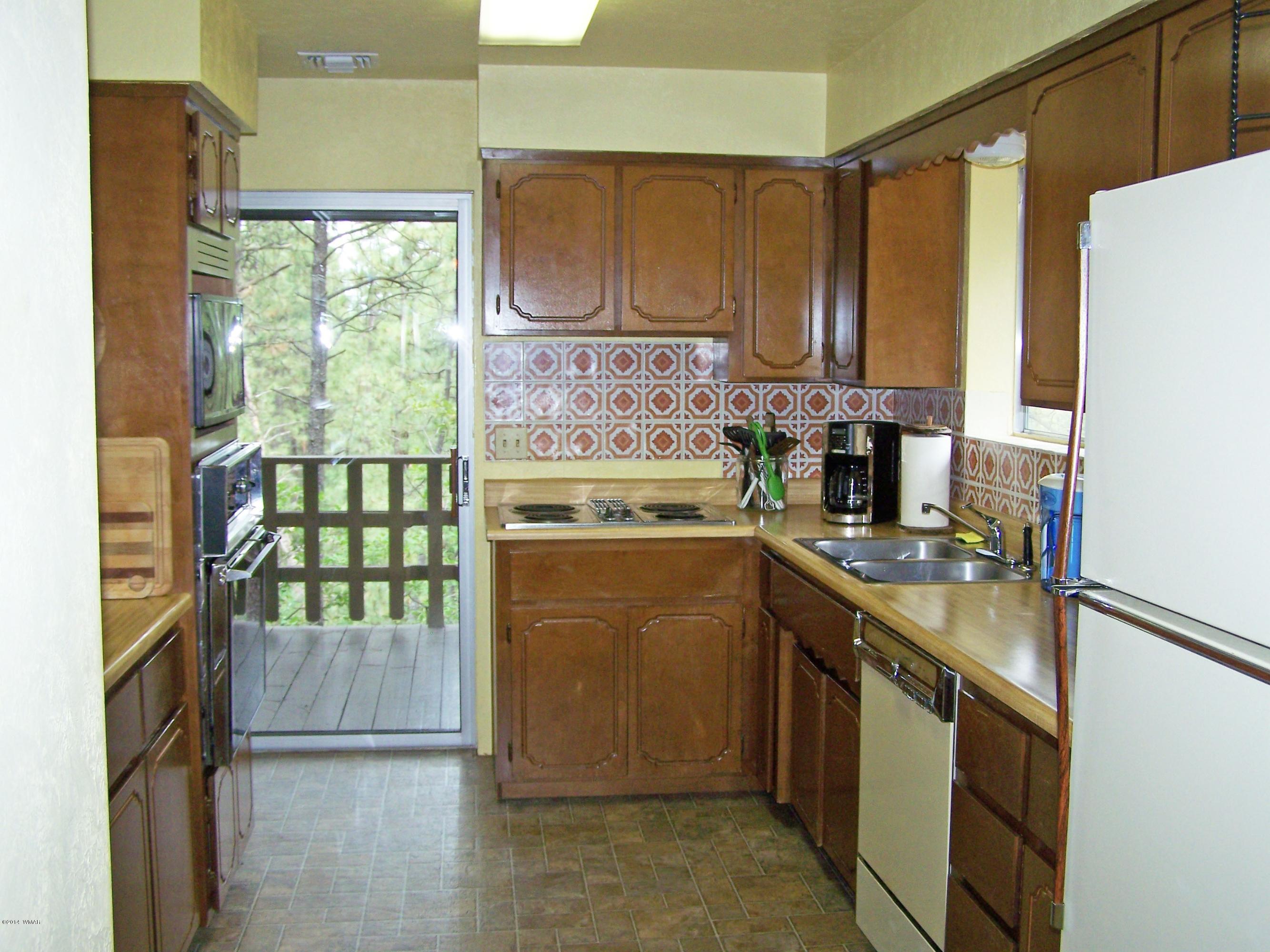 7 County Road 2135 Alpine, AZ 85920 - Photo 6 of 16 a kitchen with stainless steel appliances granite countertop a stove a sink and a refrigerator