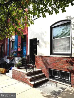 a front view of a building with cars parked