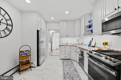 a kitchen with stainless steel appliances a stove a refrigerator and a cabinets