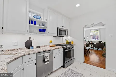 a kitchen with a sink a stove and cabinets
