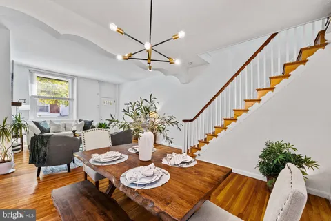 a view of a dining room and livingroom with furniture wooden floor a chandelier