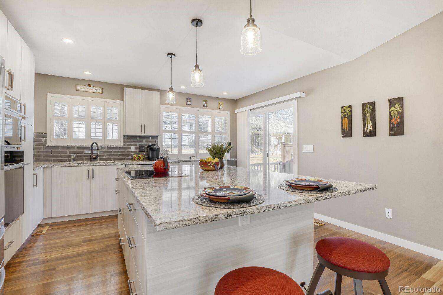 47 Canongate Lane Highlands Ranch, CO 80130 - Photo 11 of 22 a kitchen with stainless steel appliances granite countertop a stove a sink a refrigerator and white cabinets with wooden floor