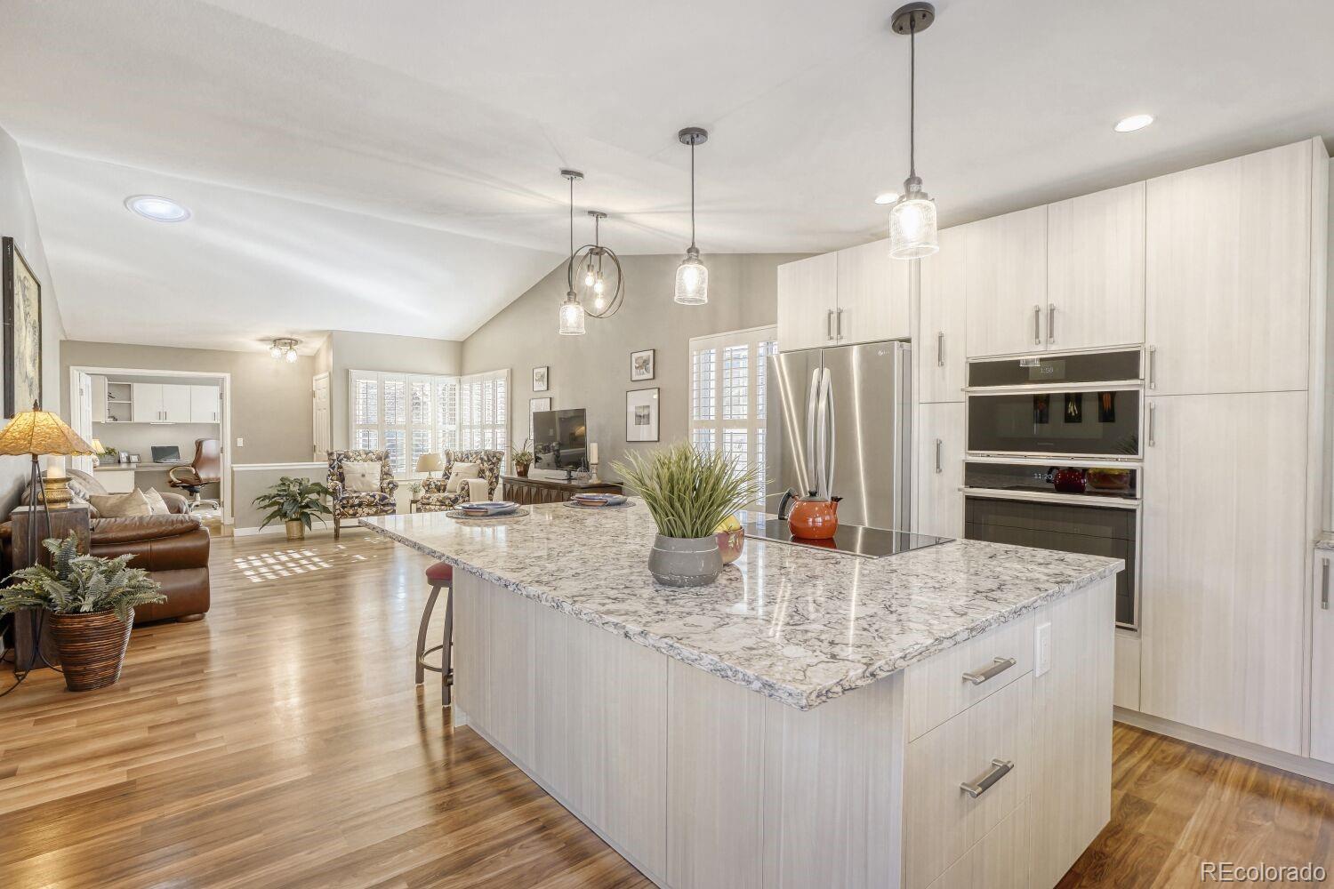 47 Canongate Lane Highlands Ranch, CO 80130 - Photo 9 of 22 a kitchen with stainless steel appliances granite countertop a kitchen island a stove a refrigerator a oven a sink with island cabinets and wooden floor