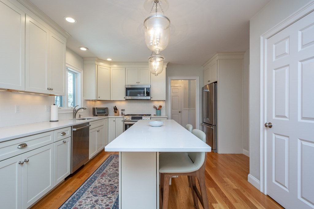 7 July Road Sudbury, MA 01776 - Photo 5 of 41 a kitchen with stainless steel appliances a table chairs refrigerator and cabinets