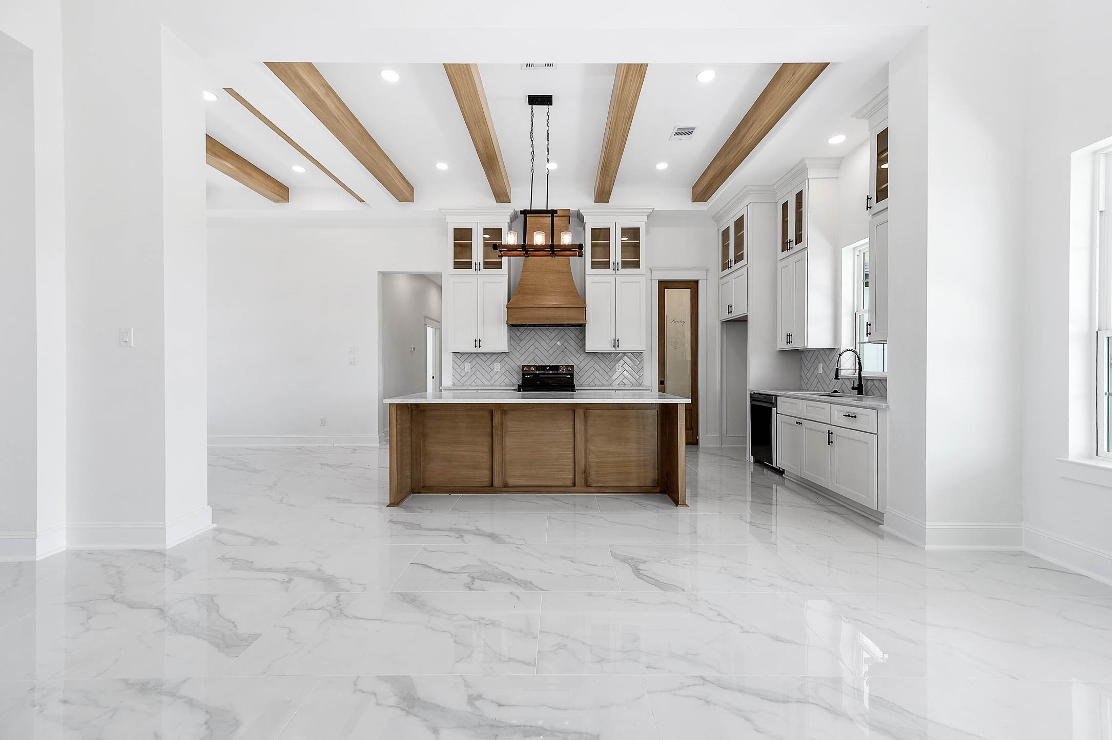 13911 Routt Point Road Needville, TX 77461 - Photo 6 of 19 Open-concept living and kitchen area featuring beautiful wood accents, custom cabinetry, and a spacious layout.