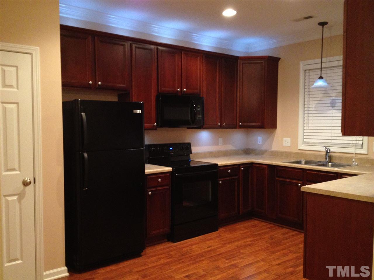 4112 Wyrick Court Raleigh, NC 27604 - Photo 2 of 18 a kitchen with wooden cabinets and a sink
