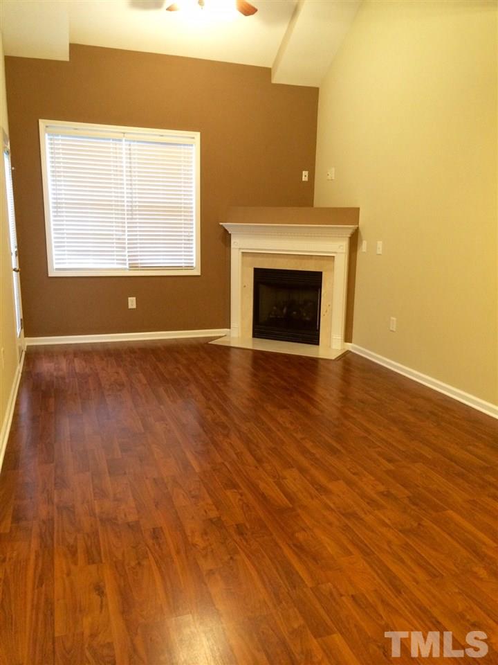 4112 Wyrick Court Raleigh, NC 27604 - Photo 5 of 18 an empty room with wooden floor a fireplace and windows
