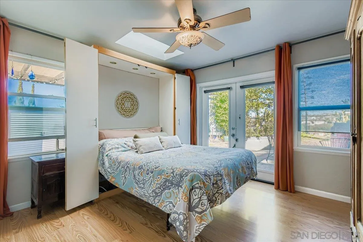 3275 East Virgo Road San Diego, CA 92105 - Photo 14 of 38 a bedroom with a large bed and a chandelier