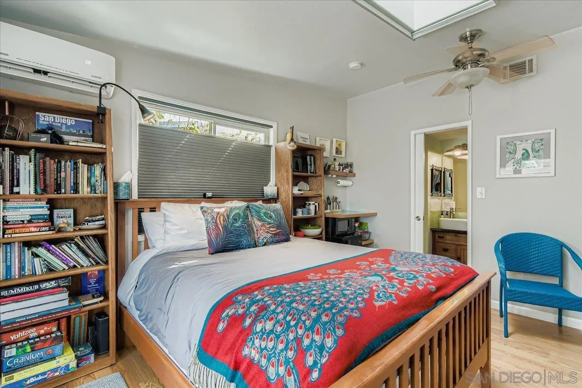 3275 East Virgo Road San Diego, CA 92105 - Photo 16 of 38 a bedroom with a bed a book shelf and a book shelf