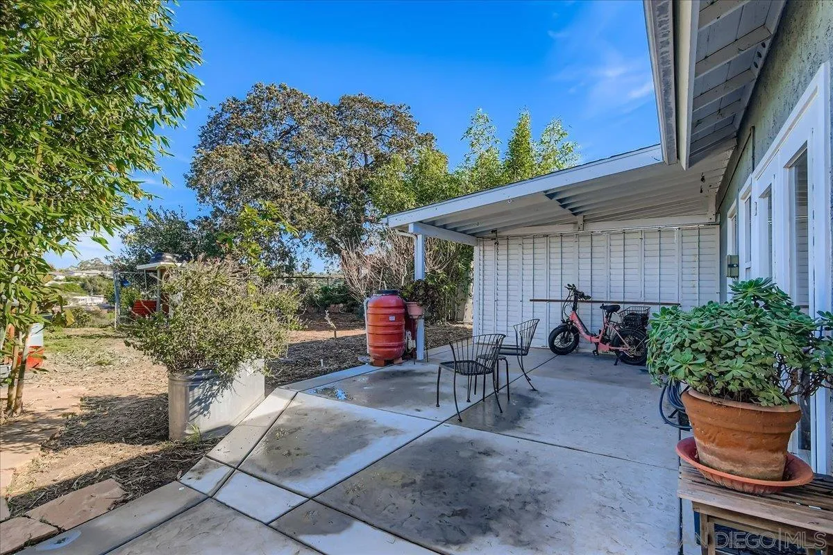3275 East Virgo Road San Diego, CA 92105 - Photo 21 of 38 a view of a patio with table and chairs potted plants and wooden fence