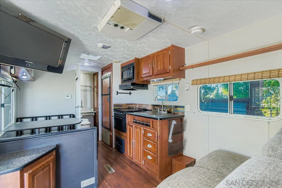 3275 East Virgo Road San Diego, CA 92105 - Photo 26 of 38 a kitchen with stainless steel appliances granite countertop a stove a sink dishwasher and a refrigerator