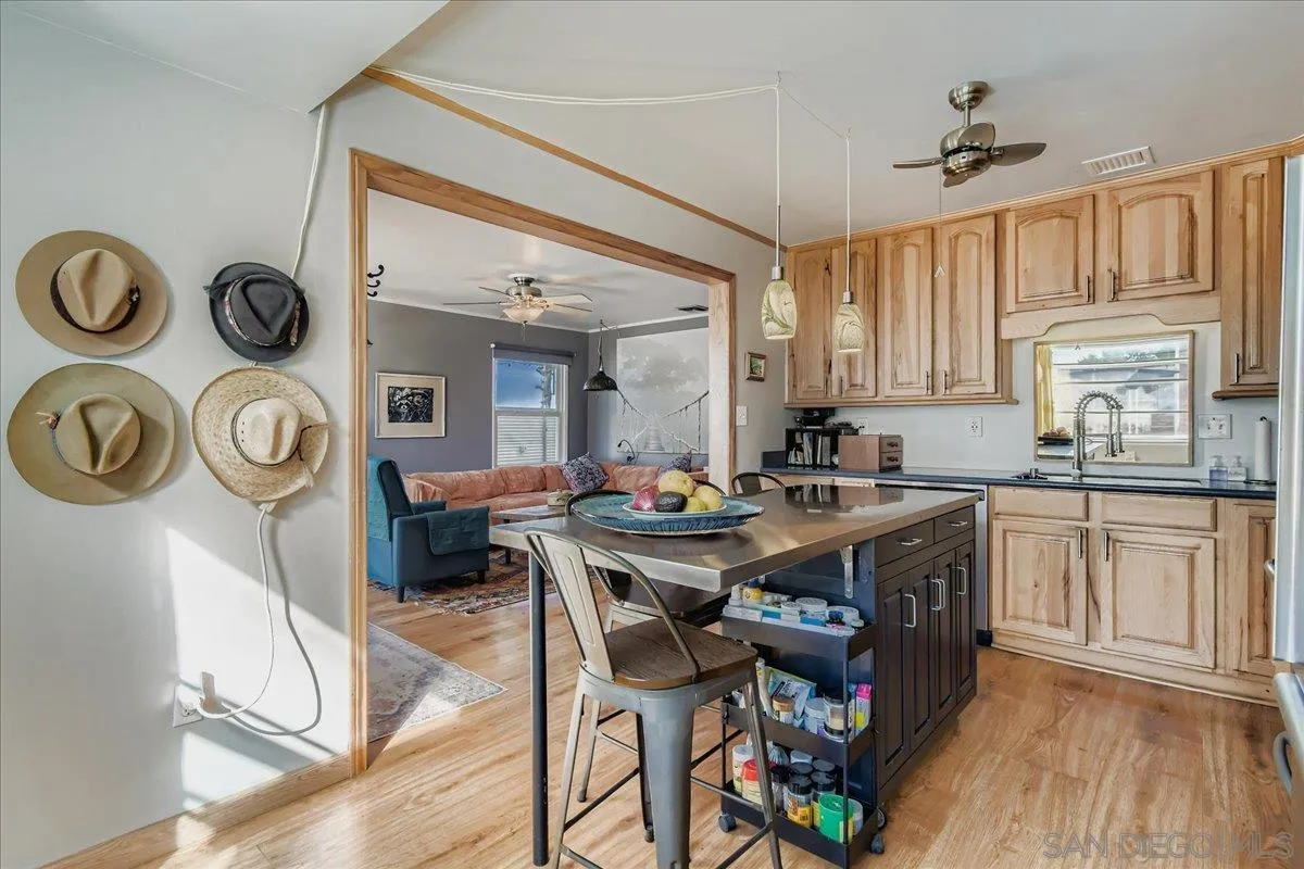 3275 East Virgo Road San Diego, CA 92105 - Photo 9 of 38 a view of a kitchen area with furniture and wooden floor