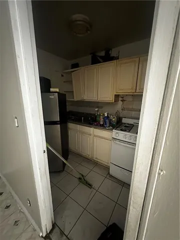 a kitchen with a sink a refrigerator a stove and cabinets