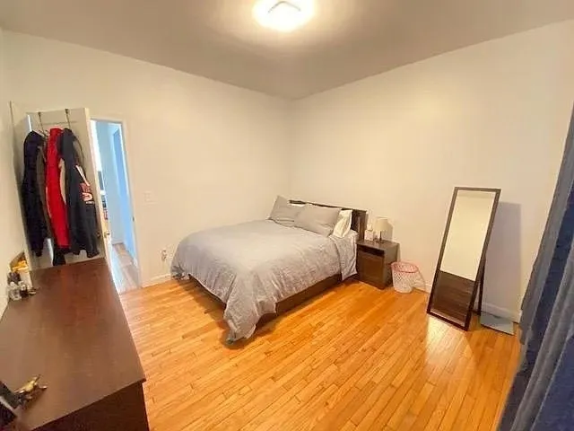 a bedroom with a bed and a flat tv screen on a dresser