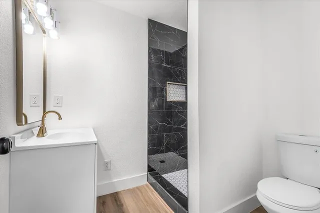 a bathroom with a sink a toilet and shower