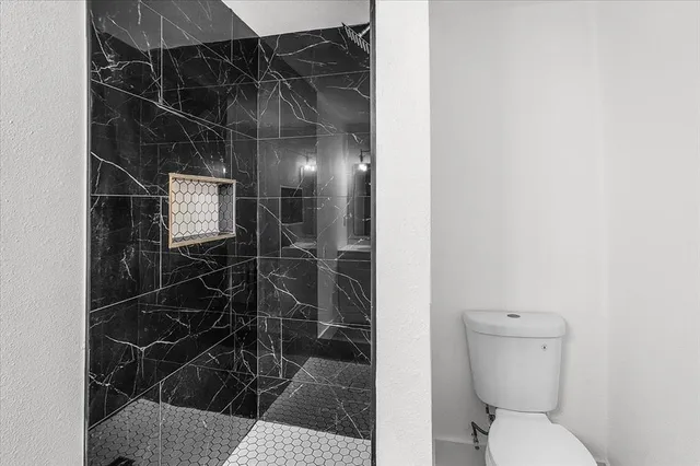 a bathroom with a toilet and a shower