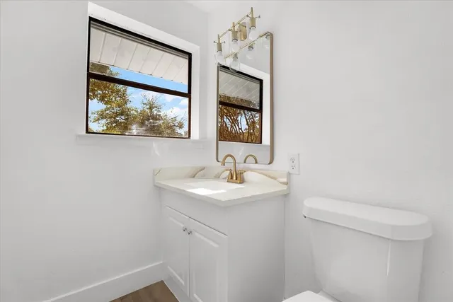 a bathroom with a sink a toilet and mirror