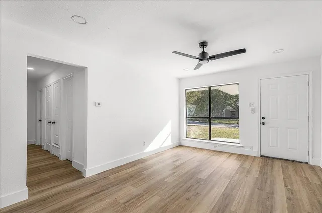 a view of a livingroom with wooden floor and a ceiling fan