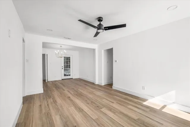 a view of a room with wooden floor and a ceiling fan