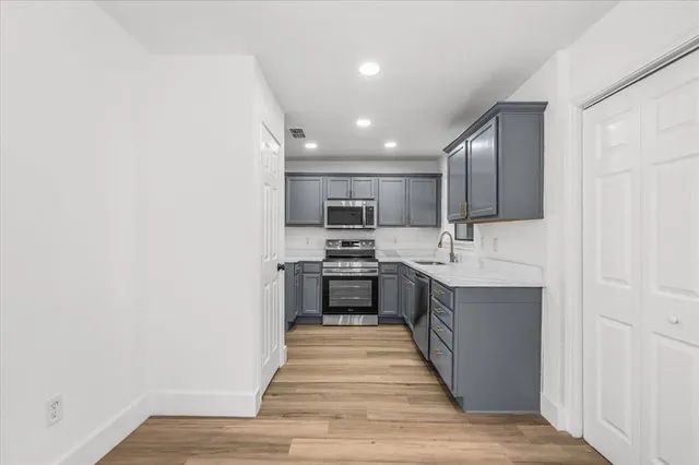a large kitchen with a sink and stainless steel appliances