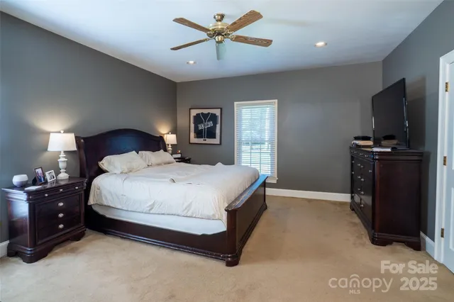 a spacious bedroom with a bed and wooden floor