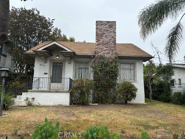 a front view of a house with a garden and palm trees