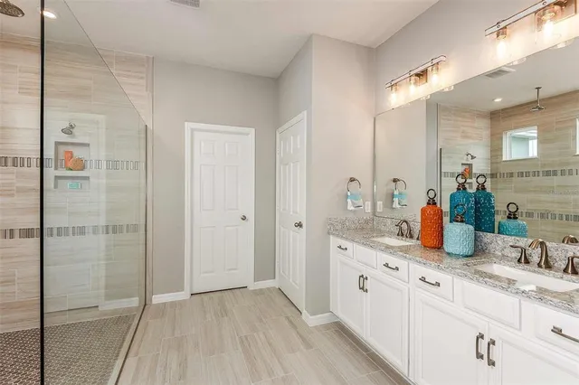 a bathroom with a double vanity sink and mirror