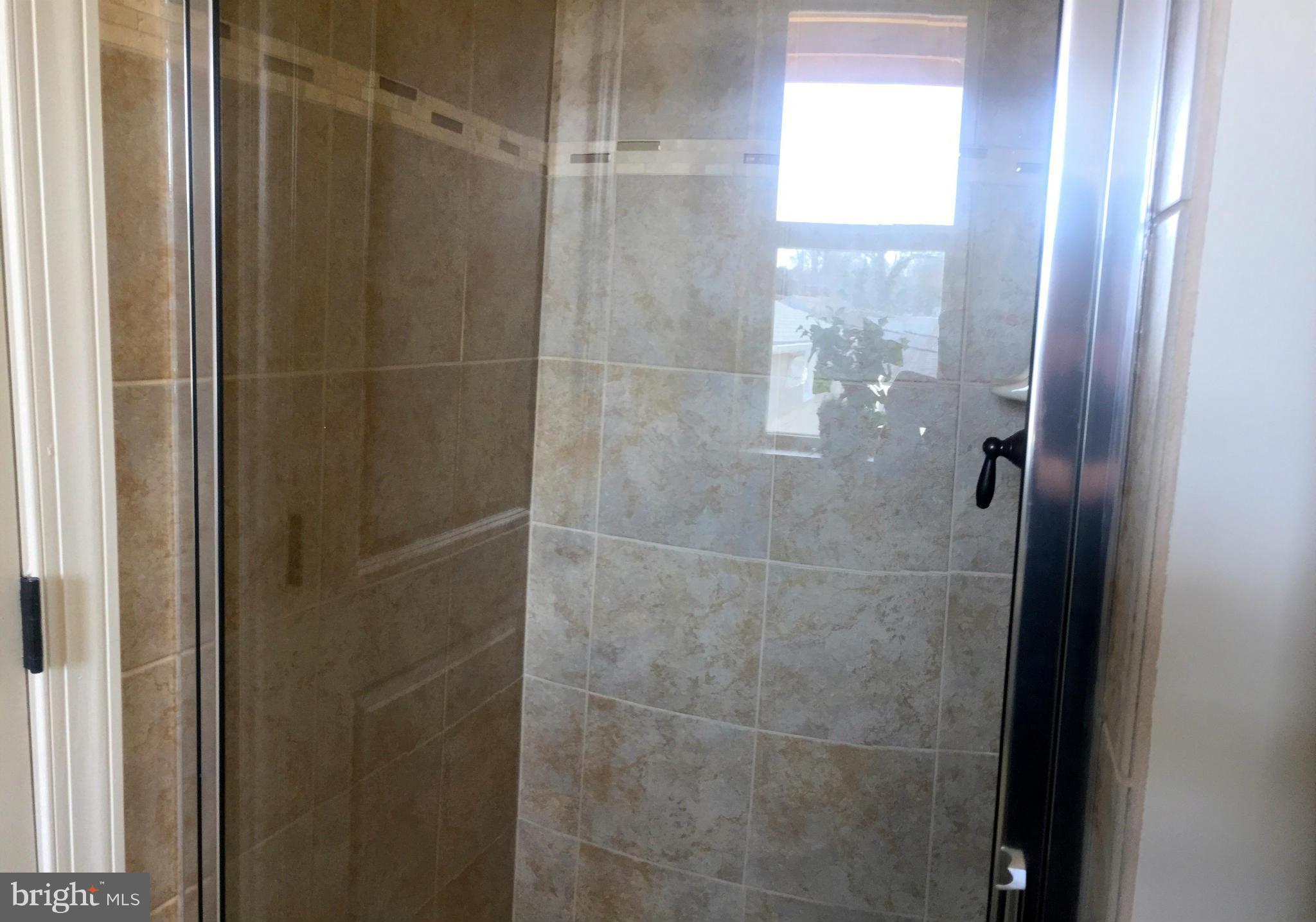1011 Overbrook Road Baltimore, MD 21239 - Photo 19 of 24 a bathroom with a glass shower door