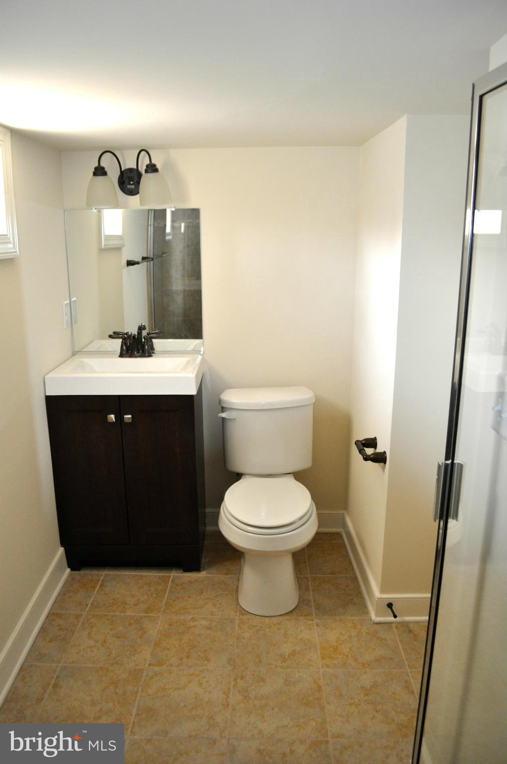 1011 Overbrook Road Baltimore, MD 21239 - Photo 21 of 24 a bathroom with a sink a toilet and mirror