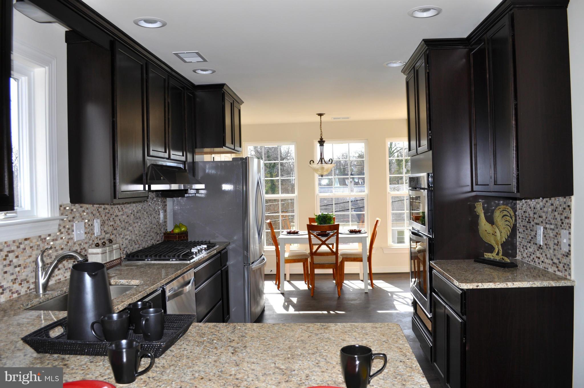 1011 Overbrook Road Baltimore, MD 21239 - Photo 8 of 24 a kitchen with granite countertop a stove a sink a refrigerator and wooden cabinets