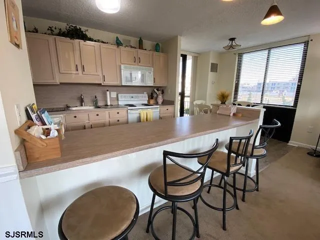 a kitchen with kitchen island granite countertop a table chairs sink and cabinets