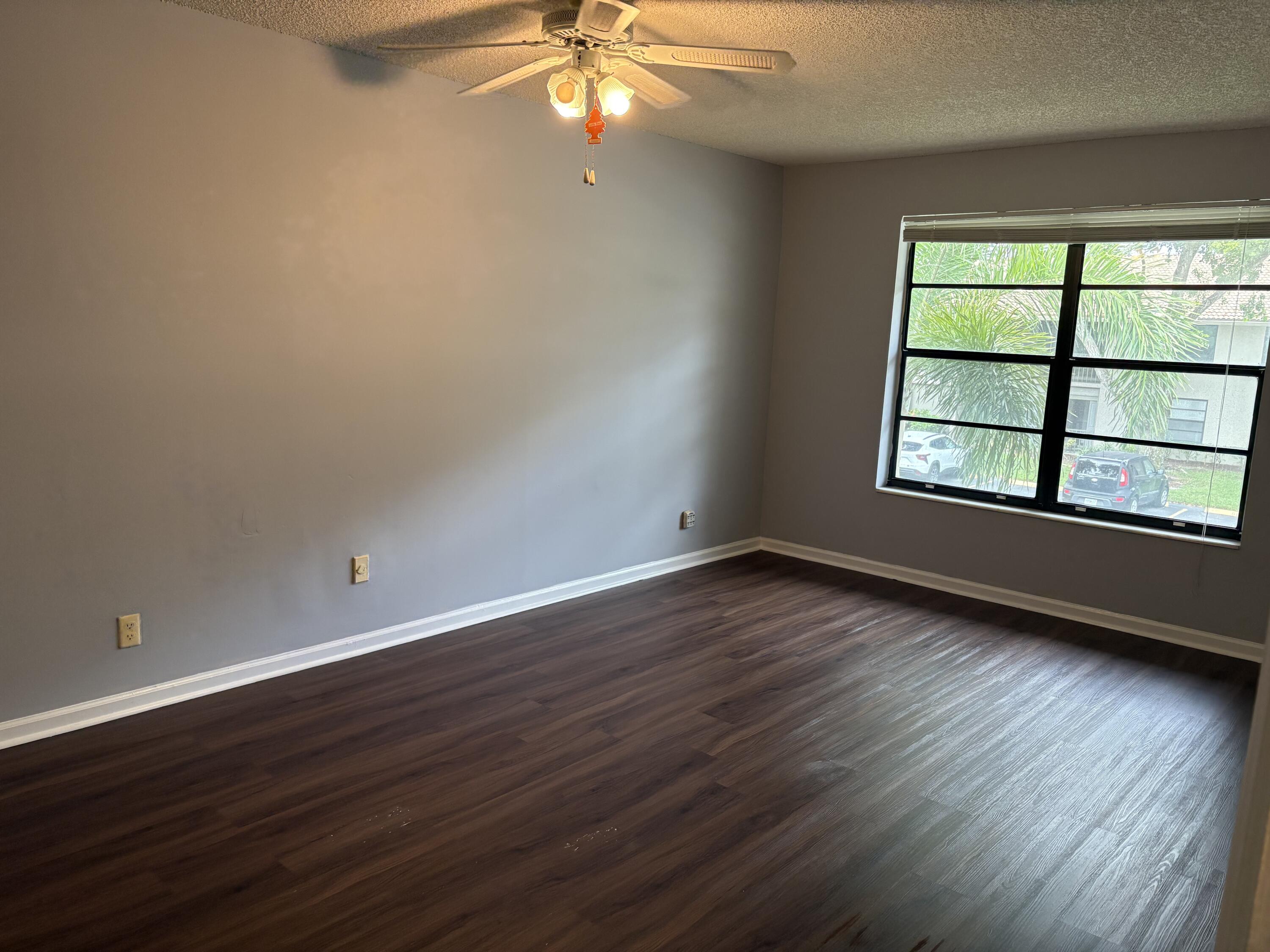 9845 Pineapple Tree Drive, Unit 208 Boynton Beach, FL 33436 - Photo 4 of 21 wooden floor in an empty room with a window