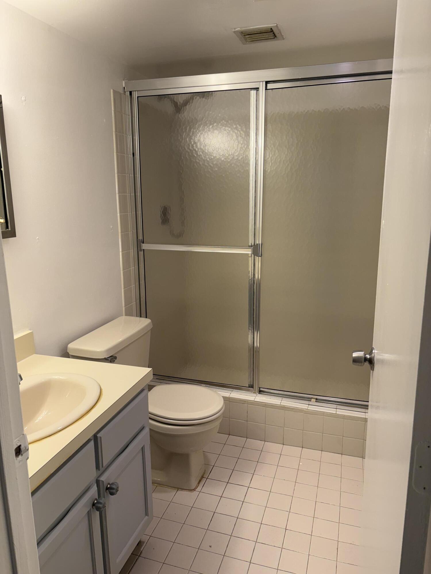 9845 Pineapple Tree Drive, Unit 208 Boynton Beach, FL 33436 - Photo 7 of 21 a bathroom with a granite countertop sink toilet and shower