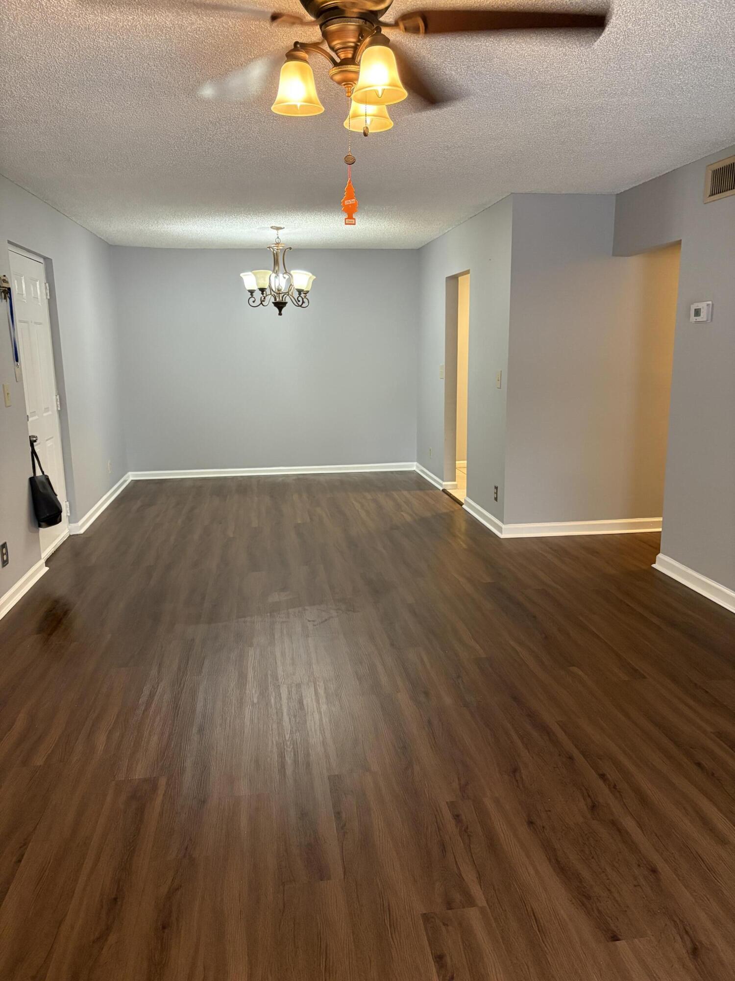 9845 Pineapple Tree Drive, Unit 208 Boynton Beach, FL 33436 - Photo 10 of 21 wooden floor in an empty room with a window