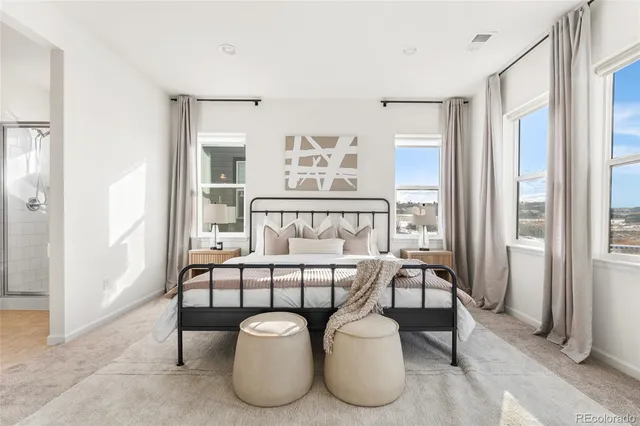 a bedroom with furniture and a large window