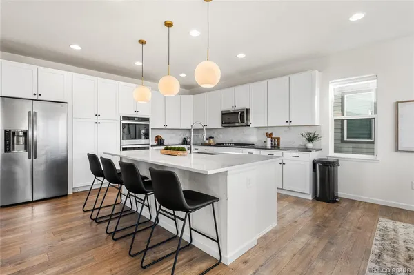 a kitchen with kitchen island granite countertop a sink a counter space appliances and cabinets